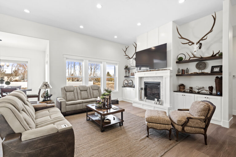 Modern living room with fireplace, mounted TV, and deer antlers decor.