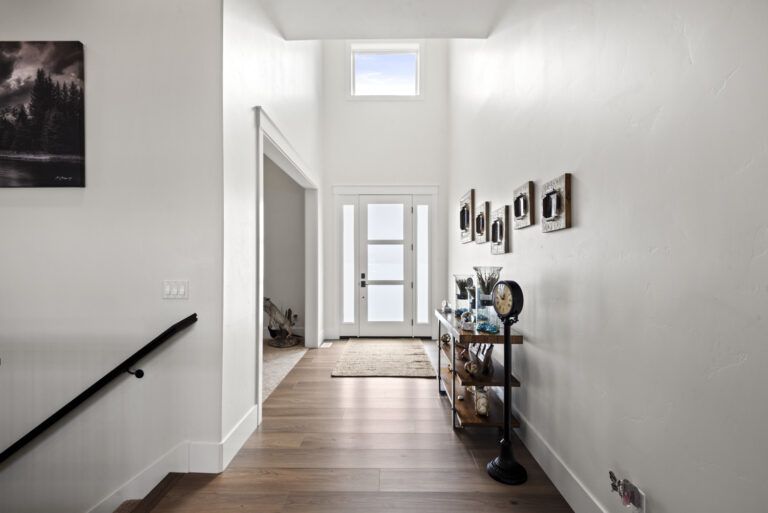 Bright hallway with art, skylight, and wooden floor.