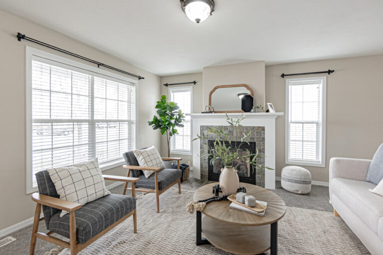 Tidy living room with modern decor, ample natural light, and comfortable furniture.