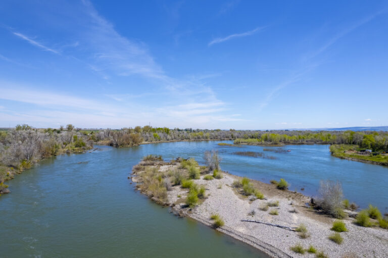 Aerial view of a river with islands and lush greenery surrounding it.