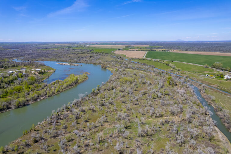 Aerial view of a river with islands and lush greenery surrounding it.